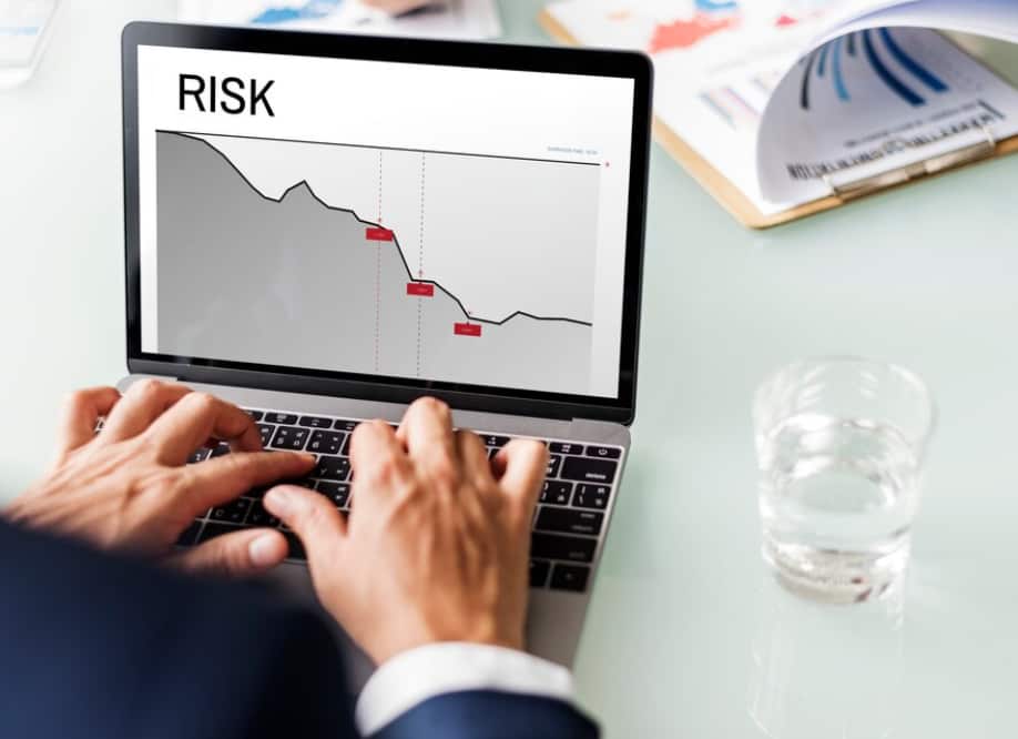 A person analyzing a risk graph on a laptop screen
